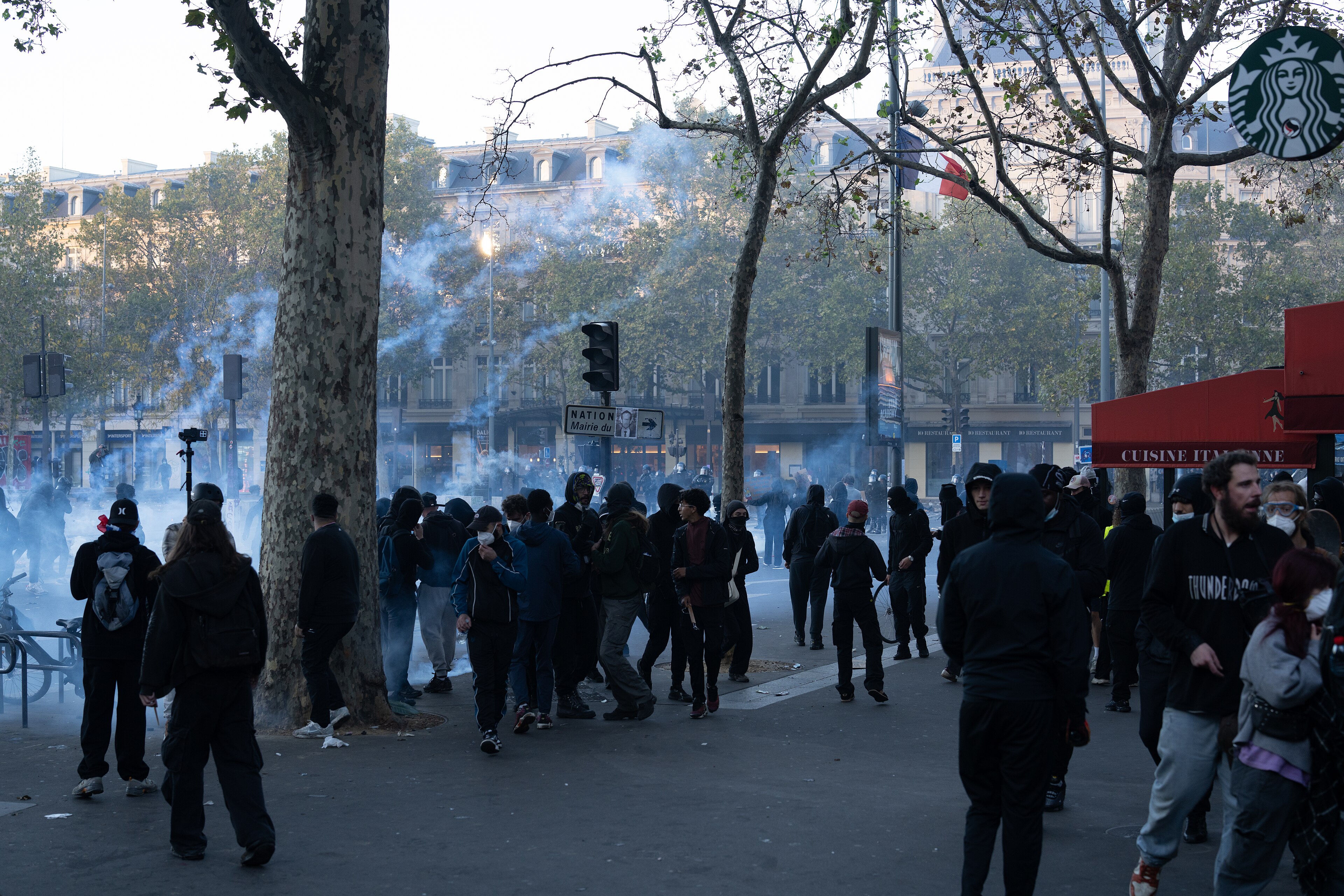 Demonstrators stand in drifting tear gas at Place de la République in Paris during the October 2026 riots.