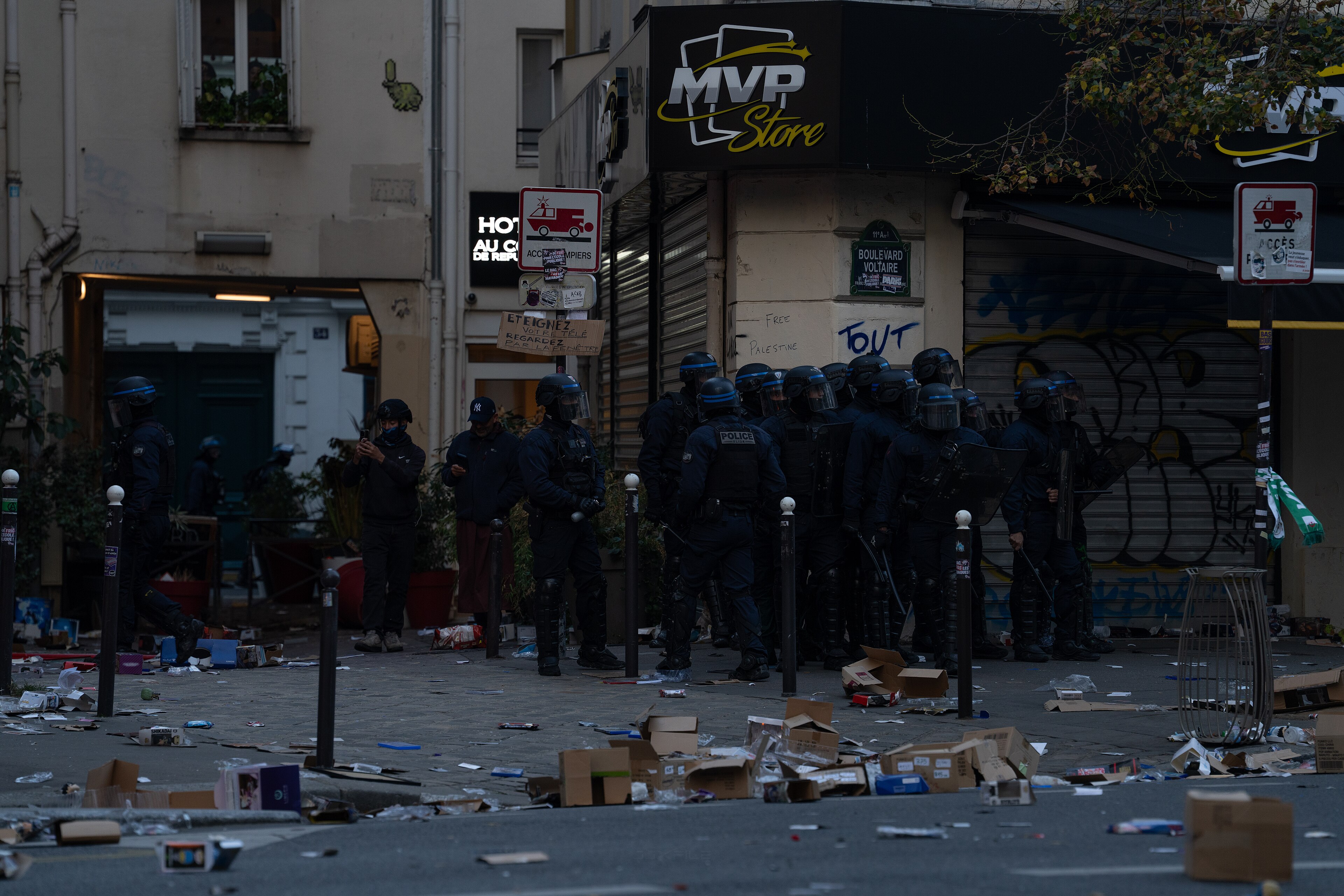 Riot police stand outside a looted shop in Paris on 17 October 2026, during the unrest that began with protests over school conditions and the cost of living.