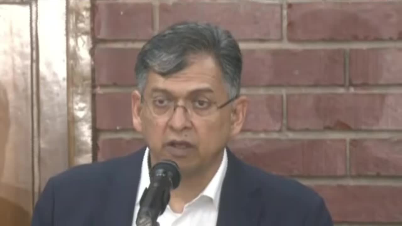 Home Minister Salahuddin Ahmed speaking into a microphone at a parliament briefing, 24 October 2026